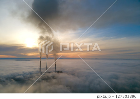 Coal power plant high pipes with black smoke moving upwards polluting atmosphere. Production of electrical energy with fossil fuel concept 127503896