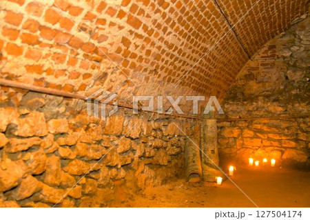 A view of old corridors lit by candles. Old cellar spaces lit by candles. The concept of romance and old times 127504174