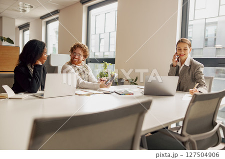 Professional women are effectively collaborating in a modern and vibrant office space setting Professional women are effectively collaborating in a modern and vibrant office space setting 127504906