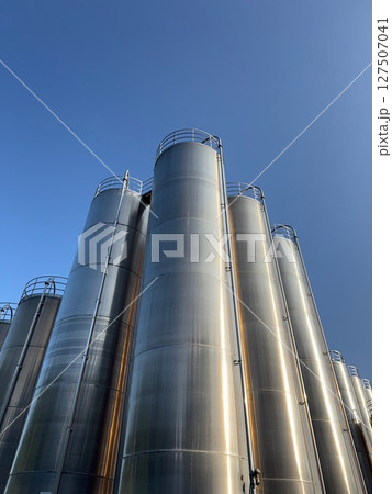 Large stack of metal tanks with a clear blue sky in the background 127507041