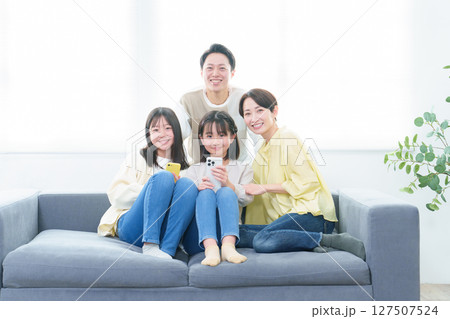 リビングでスマートフォンを使う親子のポートレート リビングでスマートフォンを使う親子のポートレート 127507524