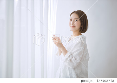 リビングで水を飲む若い女性 リビングで水を飲む若い女性 127508718