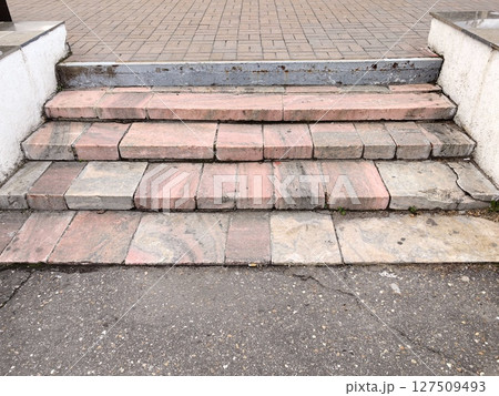 elegant marble staircase leading to an entrance patterned stone steps displaying wear and history. elegant marble staircase leading to an entrance patterned stone steps displaying wear and history. 127509493