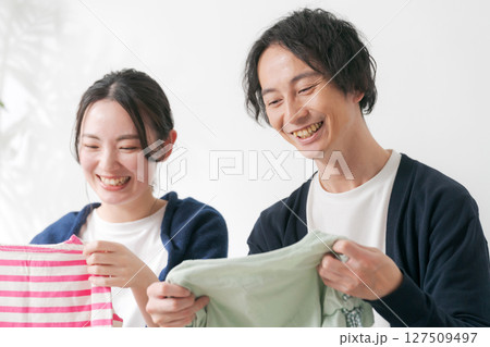 洋服を片付ける夫婦 127509497