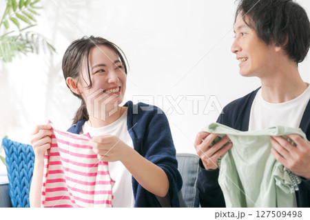 洋服を片付ける夫婦 127509498