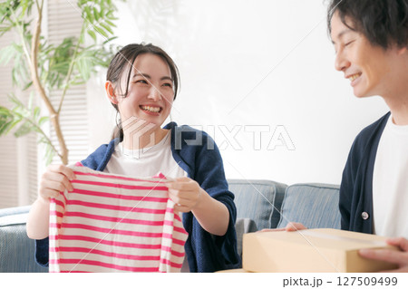 洋服を片付ける夫婦 127509499
