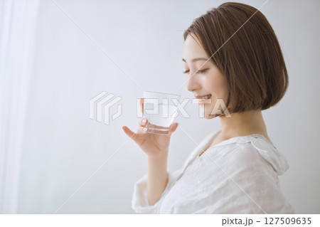 リビングで水を飲む若い女性 リビングで水を飲む若い女性 127509635