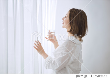 リビングで水を飲む若い女性 リビングで水を飲む若い女性 127509637