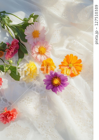 Brightly colored flowers on a delicate lace background 127510389