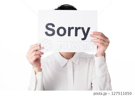 Sorryと書かれた紙を持つ白いシャツを着た人物 Sorryと書かれた紙を持つ白いシャツを着た人物 127511050