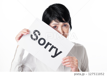 Sorryと書かれた紙を持つ白いシャツを着た中年女性 Sorryと書かれた紙を持つ白いシャツを着た中年女性 127511052