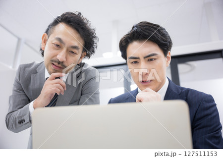 パソコンの画面を見ながら考える上司と部下　仕事の問題とpdca 127511153