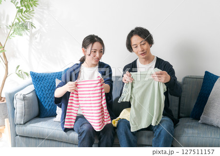 洋服を持つ夫婦 洋服を持つ夫婦 127511157