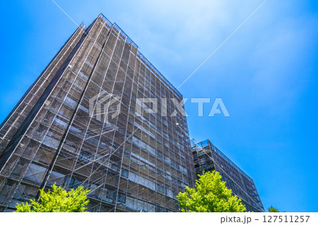 日本の横浜都市景観　マンションの補修や点検等、足場や防護ネットなど。ネットの外に衛星アンテナが… 127511257