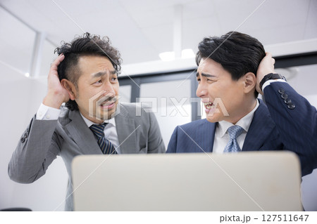 パソコンを見て部下と一緒に驚くビックリする上司　 サイバーDDoS攻撃？ 127511647