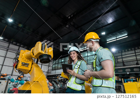 Robotic engineer team automatic holding tablet checking Plan system of automation robot arms machine in factory. Service programming machinery welding robots in production at factory industry. Robotic engineer team automatic holding tablet checking Plan system of automation robot arms machine in factory. Service programming machinery welding robots in production at factory industry. 127512165