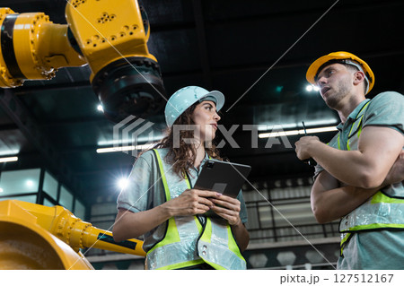 Robotic engineer team automatic holding tablet checking Plan system of automation robot arms machine in factory. Service programming machinery welding robots in production at factory industry. 127512167