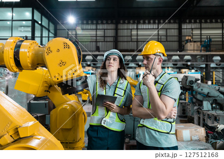 Robotic engineer team automatic holding tablet checking Plan system of automation robot arms machine in factory. Service programming machinery welding robots in production at factory industry. 127512168