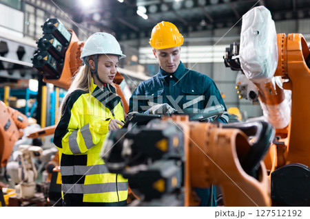 Robotic engineer team automatic checking Plan system of automation robot arms machine in factory. Programming machinery welding robots in production at factory industry. Robotic engineer team automatic checking Plan system of automation robot arms machine in factory. Programming machinery welding robots in production at factory industry. 127512192