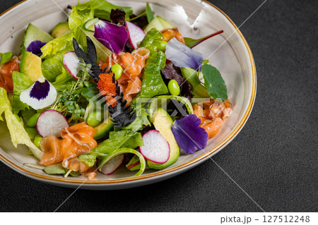 Mediterranean Avocado Salmon Salad with spinach, cherry tomatoes, avocado and red onion dressing. Concept for a tasty and healthy meal. Vegan food 127512248