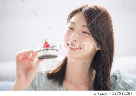 甘いスイーツを笑顔で食べる女性　スイーツは別腹 127512297