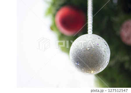 Christmas ball on tree. Closeup on Christmas tree decoration over festive background 127512547