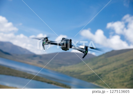 Drone flying under blue sky Drone flying under blue sky 127513605