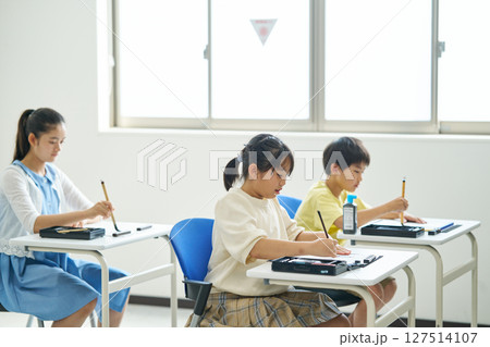 習字の授業を受ける小学生 127514107
