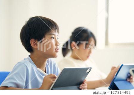 タブレット端末を操作する小学生 127514495