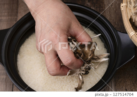 きのこの炊き込みご飯を作る工程　　土鍋の米のうえんきのこを乗せる 127514704