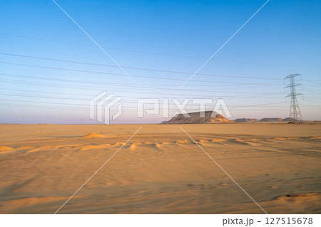 Desert Rock Formations and Power Lines in Aswan at Dawn. 127515678