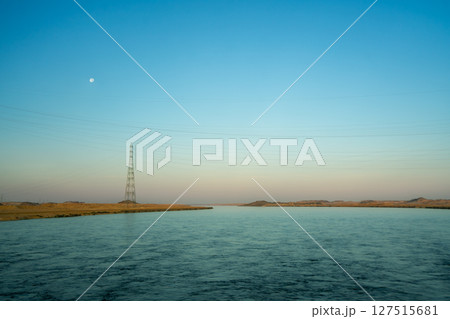Aswan Egypt Desert River Landscape with Moon and Electric Tower at Dawn. 127515681