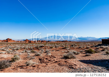 乾燥地帯に広がる赤土の大地と遠くの山並み 127516152