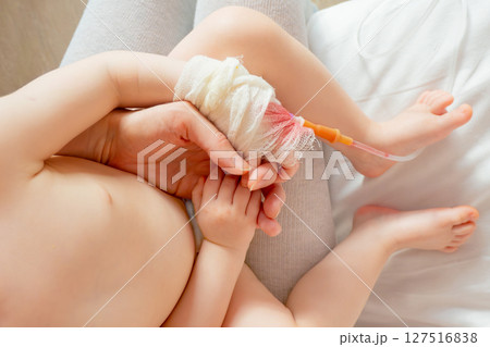 baby in hospital with intravenous saline. Sick children, are lying and being treated in beds in hospitals. baby in hospital with intravenous saline. Sick children, are lying and being treated in beds in hospitals. 127516838