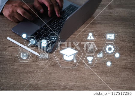 E-learning Platforms person working laptop with digital education icons floating above desk, symbolizing online learning and digital education 127517286