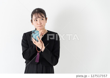 喪服の女性　悩む　スマホ 127517357