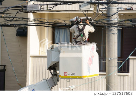 電線の端子函を開けて作業する男性 127517608