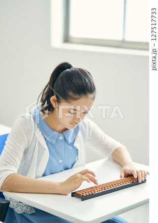 そろばんを教わる小学生 127517733