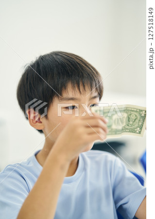 紙幣を見つめる小学生 127518149