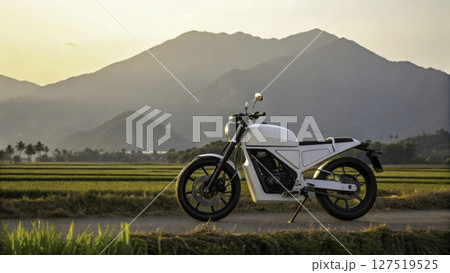 Stunning electric motorcycle parked on a rural road with mountains and rice fields at sunset 127519525