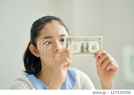 紙幣を見つめる小学生 127520708