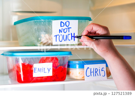 Office fridge with angry Do Not Touch My Food sticker on meal containers. Workplace humor, coworking content. Office fridge with angry Do Not Touch My Food sticker on meal containers. Workplace humor, coworking content. 127521389