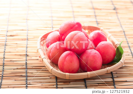 笊に盛り付けた早生スモモ 127521932