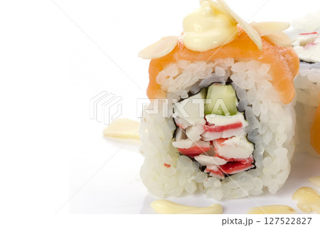 Piece of sushi with rice and salmon, drenched in sauce on a white background Piece of sushi with rice and salmon, drenched in sauce on a white background 127522827