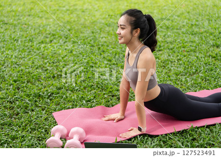 Yoga and fitness. Young woman in upward dog pose on yoga mat outdoors. Yoga and fitness. Young woman in upward dog pose on yoga mat outdoors. 127523491