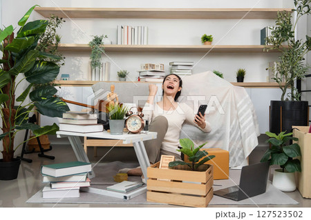 Moving and Joyful Moments. Woman expressing happiness while unpacking boxes. 127523502
