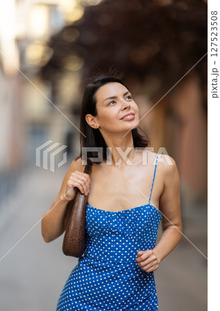 Young woman looks around on city street Young woman looks around on city street 127523508