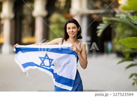 Young woman with israeli flag on city street 127523564