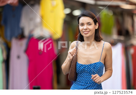 Young woman looks around at street market Young woman looks around at street market 127523574