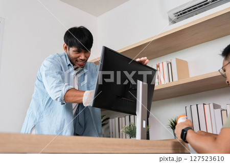 Office Maintenance and Support. A technician assisting with computer setup in a modern workspace. 127523610